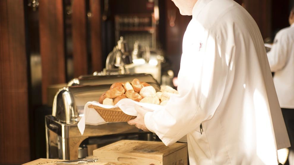 Un camarero sirve pan en un restaurante