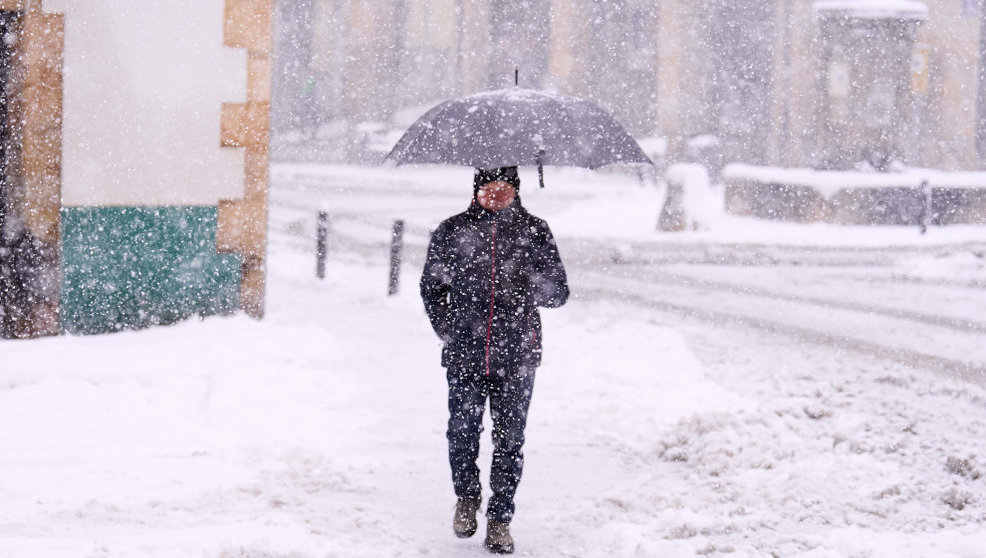 Un hombre camina bajo la nieve en Reinosa