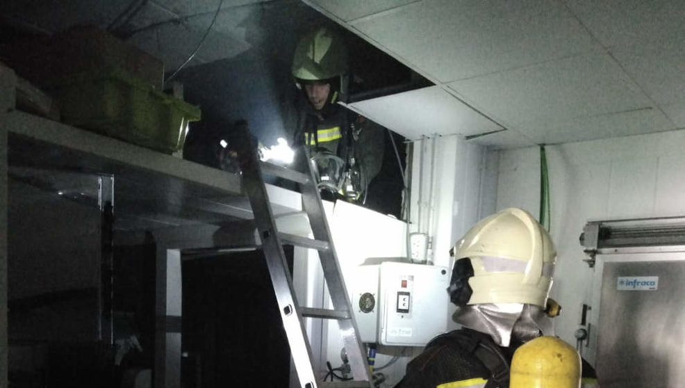 Bomberos trabajan en la extinción de un incendio en una cámara de frío en Laredo
