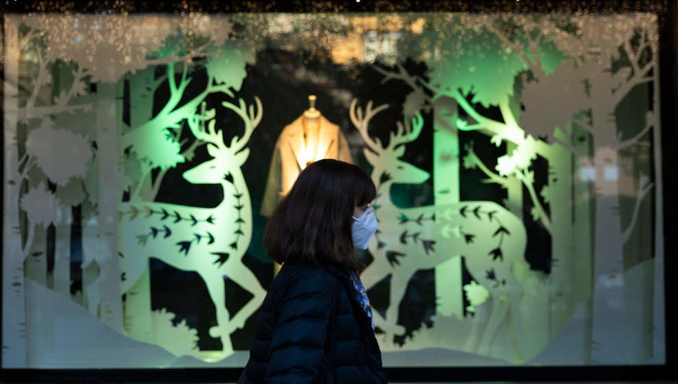 Una mujer pasa por delante de un escaparate ya decorado con motivos navideños