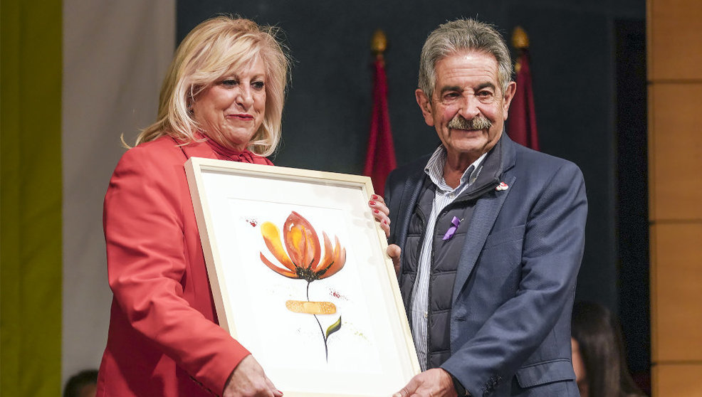 La presidenta del Colegio de Enfermeras y Enfermeros de Cantabria, Mari Luz Fernández, recoge el homenaje del PRC de manos de su secretario general, Miguel Ángel Revilla  